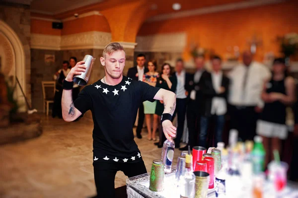 Talentueux barman effectuer des tours avec des bouteilles et des verres dans — Photo