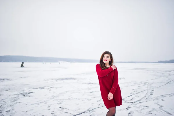 Morena modelo de talla grande en rojo contra el lago congelado en invierno da —  Fotos de Stock