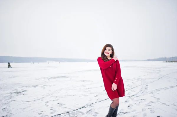 Брюнетка плюс модель розміру в червоному проти замерзлого озера на зиму да — стокове фото