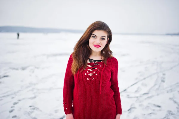 Μελαχρινή συν μέγεθος μοντέλο στο κόκκινο ενάντια σε παγωμένη λίμνη στο χειμώνα da — Φωτογραφία Αρχείου
