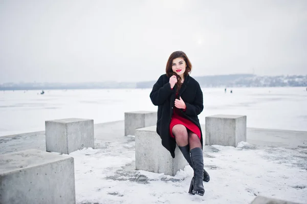 Μελαχρινή συν μέγεθος μοντέλο στο κόκκινο ενάντια σε παγωμένη λίμνη στο χειμώνα da — Φωτογραφία Αρχείου