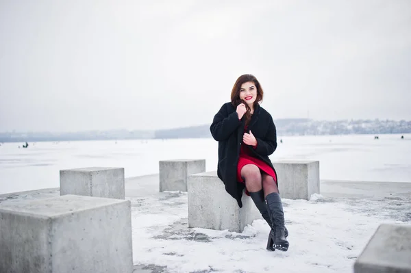 Morena plus size modelo em vermelho contra lago congelado no inverno da — Fotografia de Stock
