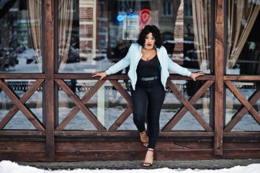 Şık Afrikalı-Amerikalı artı boyutu model ahşap café'de karşı 