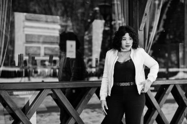 Şık Afrikalı-Amerikalı artı boyutu model ahşap café'de karşı 