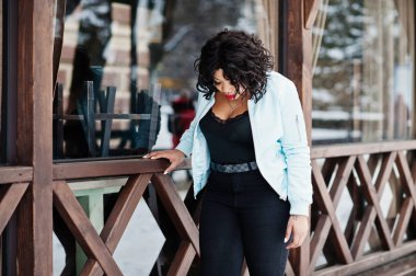 Şık Afrikalı-Amerikalı artı boyutu model ahşap café'de karşı 