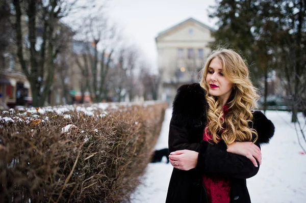 Elegantie blond meisje in de rode avondjurk en bontjas op straat — Stockfoto