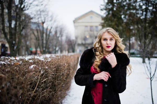 Elégance fille blonde en robe de soirée rouge et manteau de fourrure à la rue — Photo