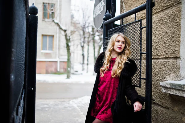 Elégance fille blonde en robe de soirée rouge et manteau de fourrure à la rue — Photo