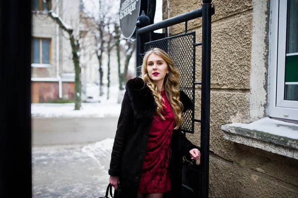 Menina loira elegante em vestido de noite vermelho e casaco de pele na rua — Fotografia de Stock