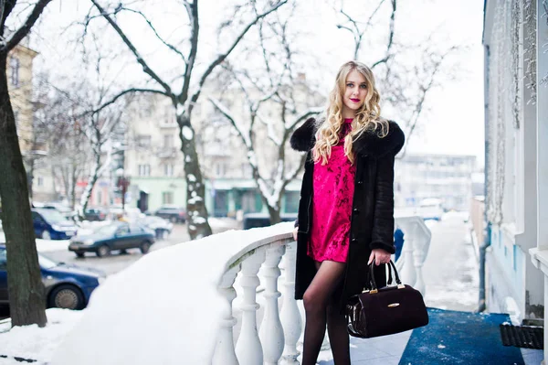 Eleganz blondes Mädchen in rotem Abendkleid und Pelzmantel auf der Straße — Stockfoto