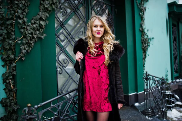 Elégance fille blonde en robe de soirée rouge et manteau de fourrure à la rue — Photo