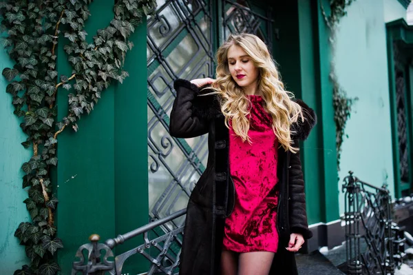 Elegancia chica rubia en vestido de noche rojo y abrigo de piel en la calle —  Fotos de Stock