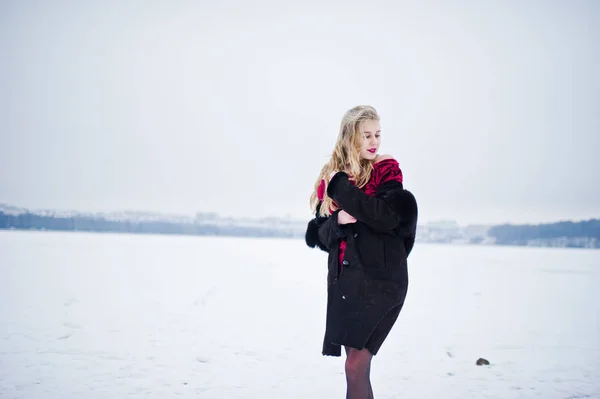 Elegance blonde girl in fur coat and red evening dress posed at — Stock Photo, Image