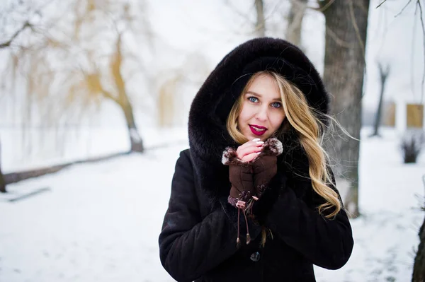 Eleganci blondýna v kožichu a červené večerní šaty představují na — Stock fotografie