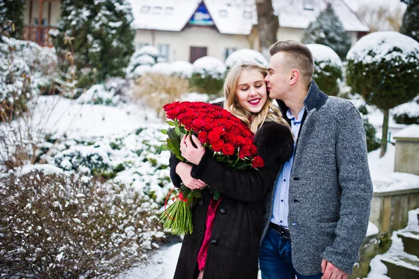 Pareja enamorada en el día de invierno con un gran ramo de 101 r — Foto de Stock