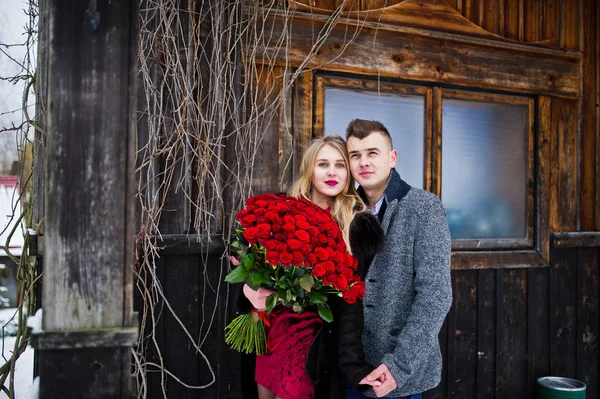 Loving couple in love at winter  day with large bouquet of 101 r — Stock Photo, Image