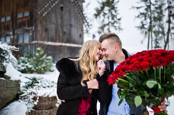 Loving couple in love at winter  day with large bouquet of 101 r — Stock Photo, Image