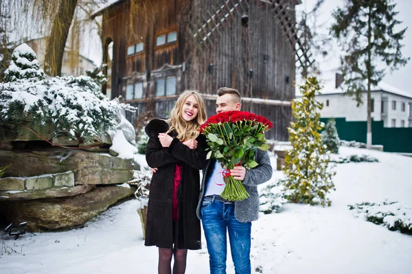 Loving couple in love at winter  day with large bouquet of 101 r — Stock Photo, Image