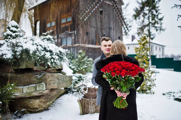 Pareja enamorada en el día de invierno con un gran ramo de 101 r — Foto de Stock
