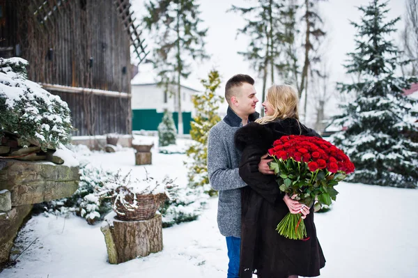 Pareja enamorada en el día de invierno con un gran ramo de 101 r — Foto de Stock