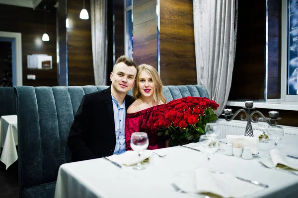 Loving couple in love at restaurant with large bouquet of 101 ro — Stock Photo, Image