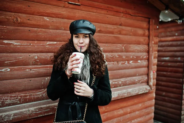 Chica mexicana rizada en gorra de cuero y taza de café de plástico en h — Foto de Stock
