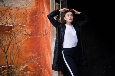 Şık uzun bacaklı esmer uzun siyah pelerin yarattığı o modelde