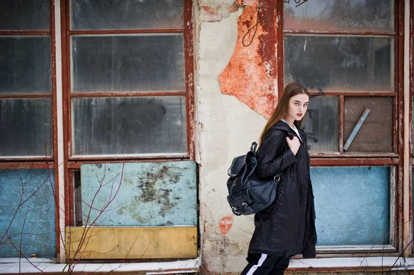 Modische lange Beine brünettes Modell in langen schwarzen Mantel posiert o — Stockfoto