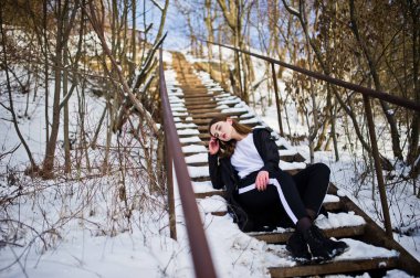 Şık uzun bacaklı esmer uzun siyah pelerin yarattığı o modelde