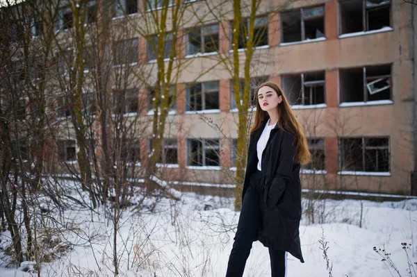 Modische lange Beine brünettes Modell in langen schwarzen Mantel posiert o — Stockfoto