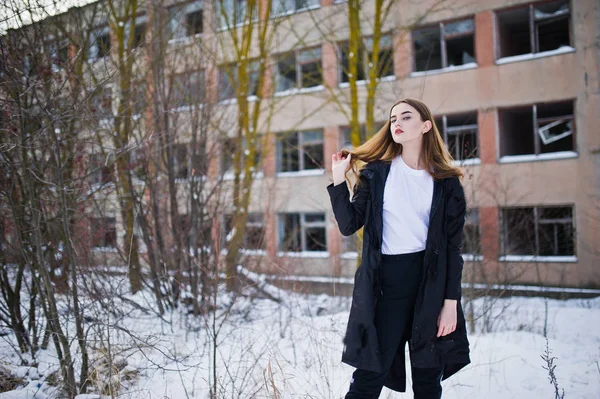 Elegante longo pernas morena modelo no longo preto capa posou o — Fotografia de Stock