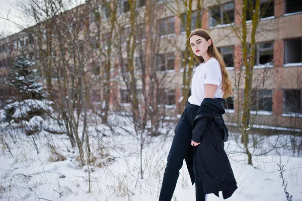 Modieuze lange benen brunette model in lange zwarte mantel stelde o — Stockfoto