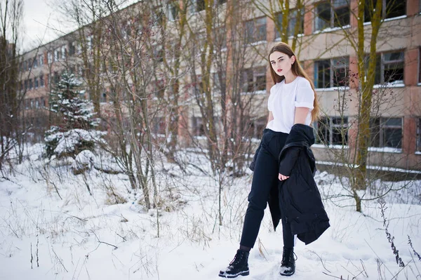 Modieuze lange benen brunette model in lange zwarte mantel stelde o — Stockfoto