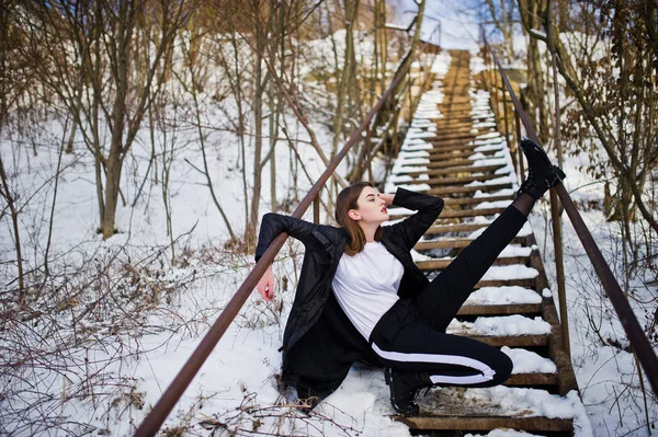 Modieuze lange benen brunette model in lange zwarte mantel stelde o — Stockfoto