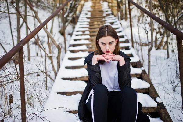 Modieuze lange benen brunette model in lange zwarte mantel stelde o — Stockfoto