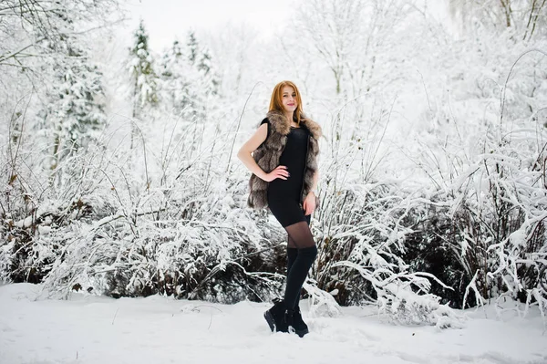 Red haired girl in fur coat walking at winter snowy park. — Stock Photo, Image
