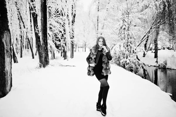 Κόκκινο πλασματάκια κορίτσι στο γούνινο παλτό περπάτημα στο χειμώνα χιονισμένο πάρκο. — Φωτογραφία Αρχείου