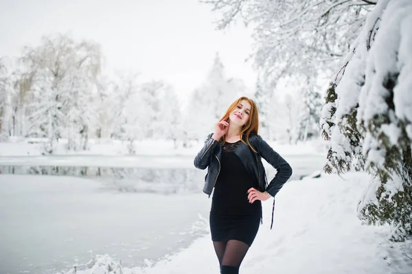 Fille aux cheveux rouges en manteau de fourrure marchant au parc enneigé d'hiver . — Photo