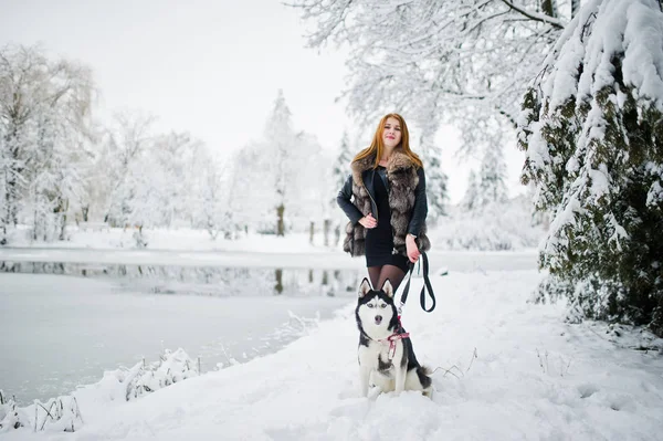 Vörös hajú lány téli napon husky kutya Park séta. — Stock Fotó