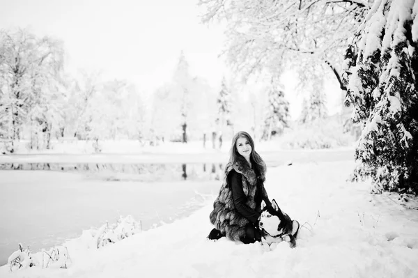 Menina de cabelos vermelhos andando no parque com cão husky no dia de inverno . — Fotografia de Stock
