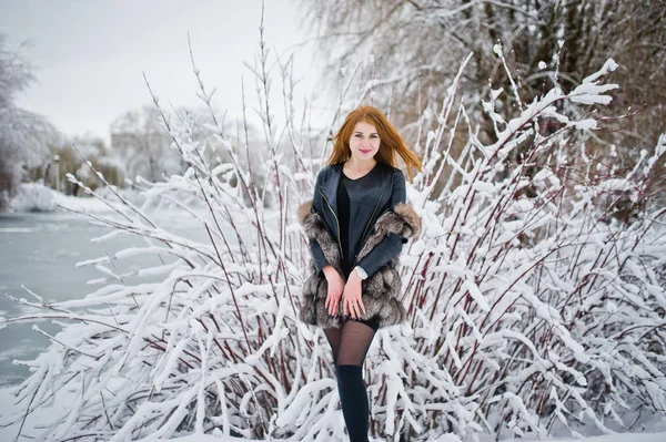 Red haired girl in fur coat walking at winter snowy park. — Stock Photo, Image