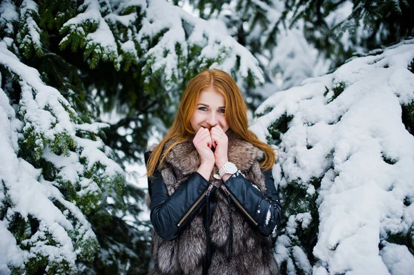 Chica pelirroja en abrigo de piel caminando en el parque nevado de invierno . — Foto de Stock