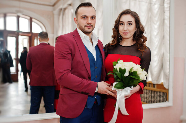 Two loved couple in love with bouquet against mirror.