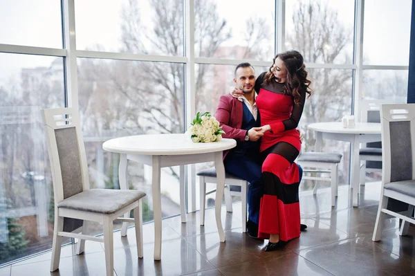 Pareja en rojo amor entre sí en el restaurante interior . — Foto de Stock