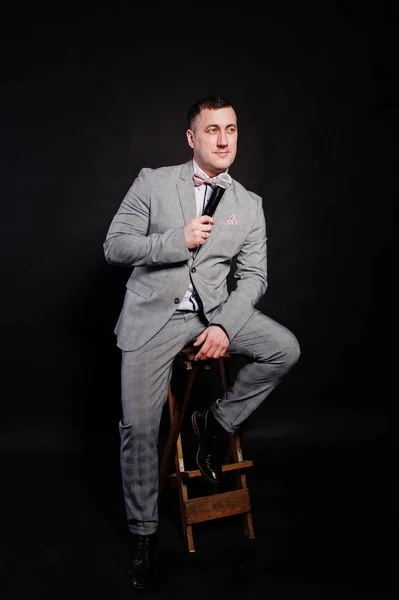 Bel homme en costume gris avec microphone contre backgrou noir — Photo