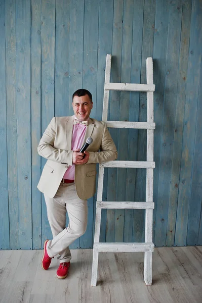 Beau homme en costume beige et chemise rose avec microphone à nouveau — Photo