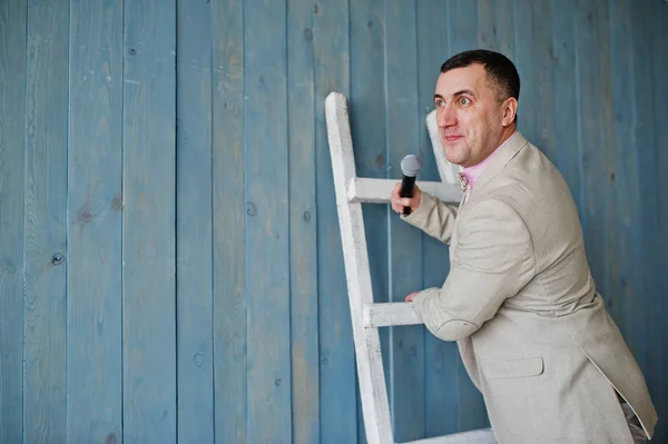 Beau homme en costume beige et chemise rose avec microphone à nouveau — Photo