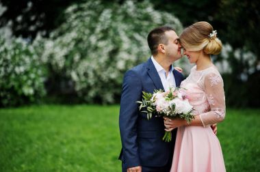 Bahar çalılar karşı aşık genç bir çift. Buket kızla. 