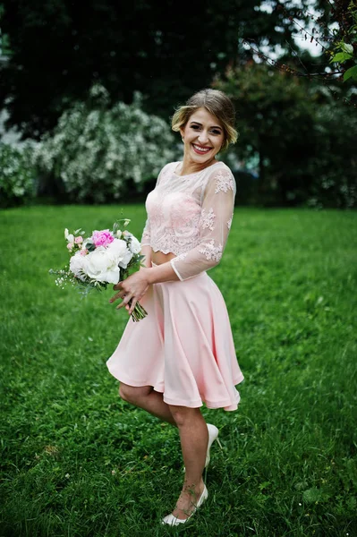 Τέλειο κορίτσι στο ροζ φόρεμα με ανθοδέσμη στα χέρια. — Φωτογραφία Αρχείου