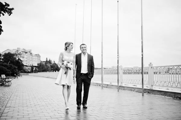 Casal jovem apaixonado andando à beira-mar. Menina com buquê . — Fotografia de Stock